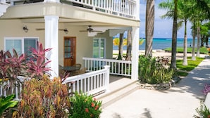 A two-story building with a balcony, a view of the ocean, and tropical landscaping. - Lawson Rock - Angelfish 100 (Roatan)