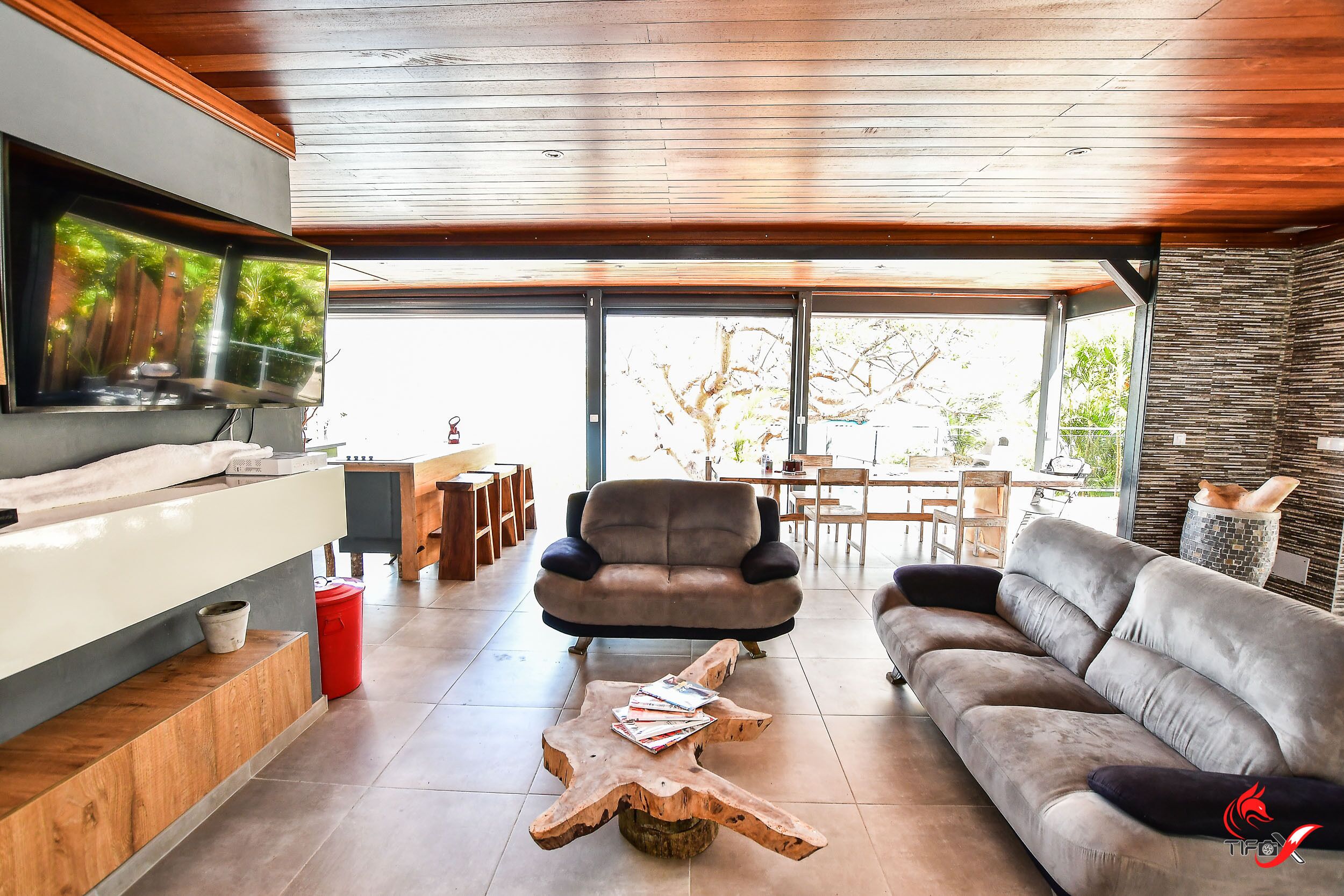 A modern living room with a sofa, a coffee table, and a TV mounted on the wall.