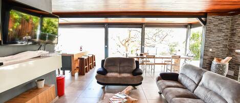 A modern living room with a sofa, a coffee table, and a TV mounted on the wall.