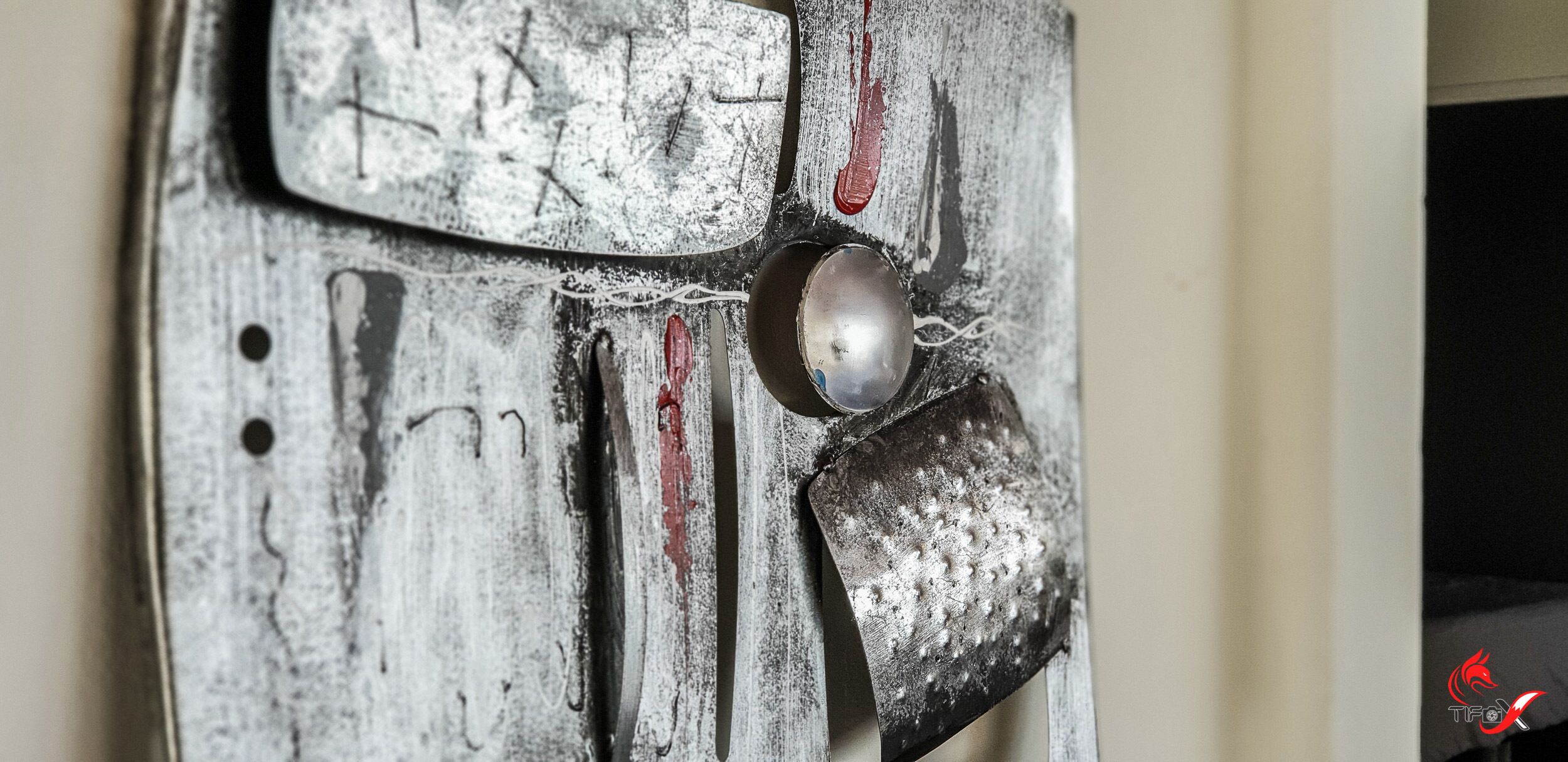 A close-up of a metallic sculpture with a spherical object and a textured surface.
