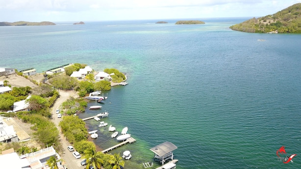 A coastal area with several boats docked at a marina, surrounded by lush greenery and small buildings. - Charming waterfront villa, labeled "4 * tourism furnished" (Le robert)