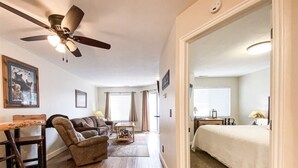 A compact living space with a ceiling fan, a sofa, a dining table, and a bed. - Inn Building Condo#113 - Ground Level, Pool Side (Garden City)