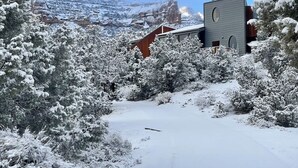 Paisatge cobert de neu amb un edifici modern i una finestra circular gran.