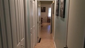 A hallway with closed doors, a tiled floor, and a light blue wall. - 1 BR located 5 minutes away from St Joseph & Hackensack Hospital. 15 min to NYC  (Paterson)