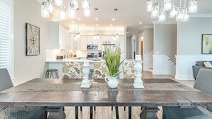 A dining area with a wooden table, two white candle holders, and a patterned runner.