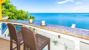 A balcony with wicker chairs and a view of the sea.