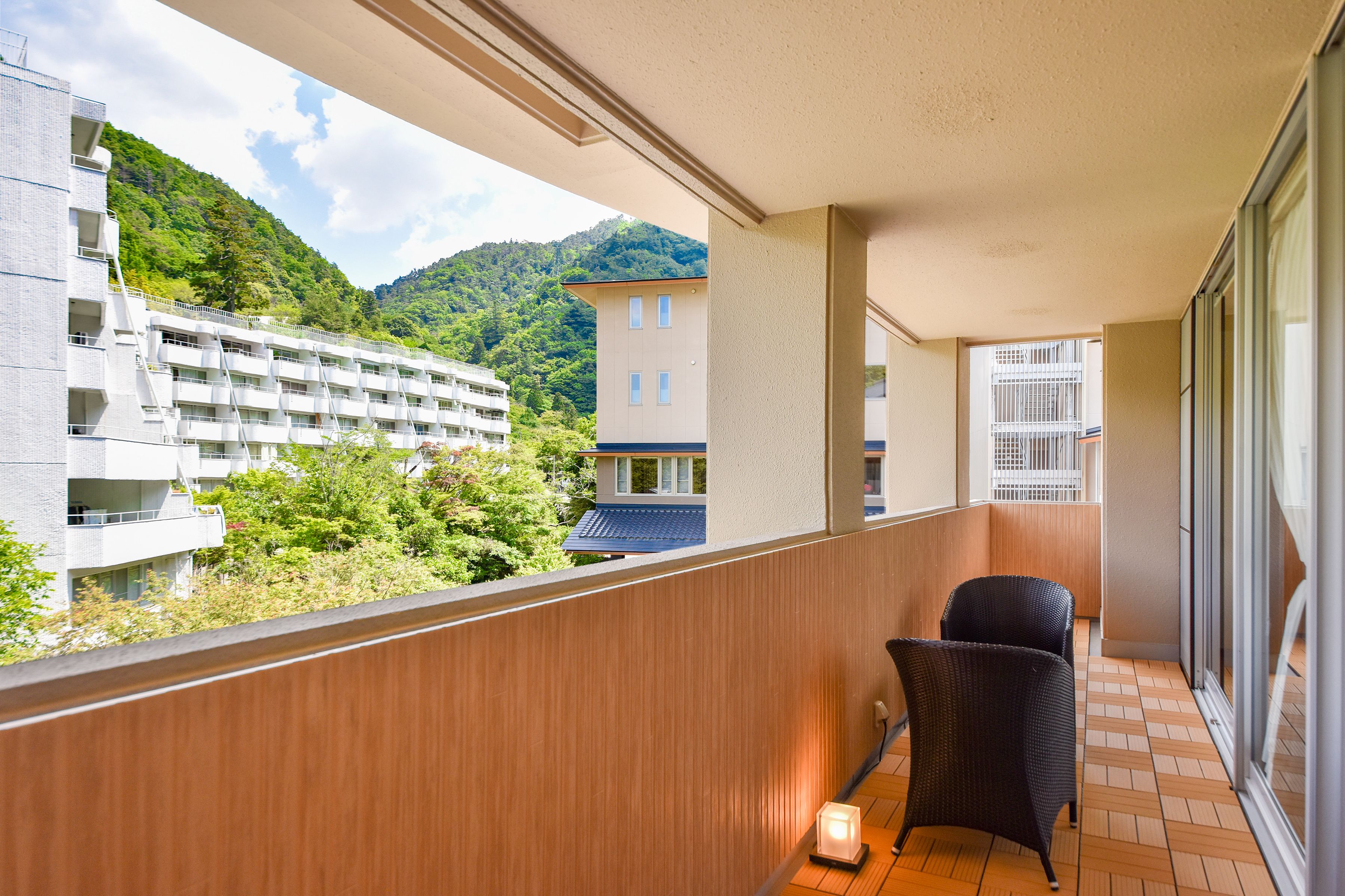 Un balcon avec vue sur un immeuble et une montagne.