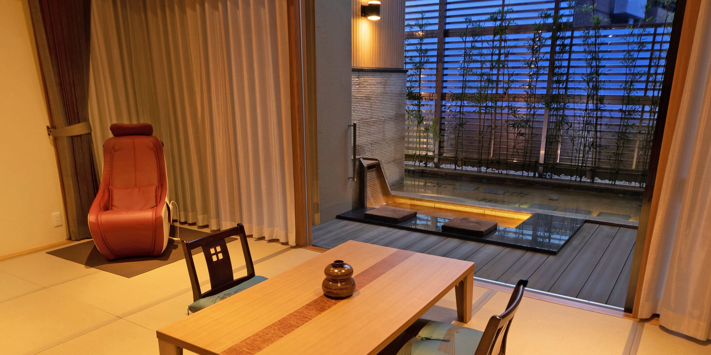 A dining area with a wooden table, chairs, and a red chair.