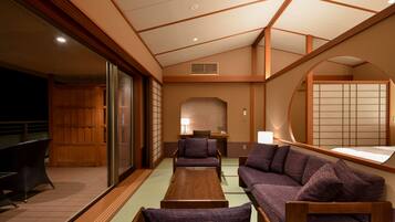 A traditional Japanese-style room with tatami flooring, low wooden tables, and purple upholstered seating.