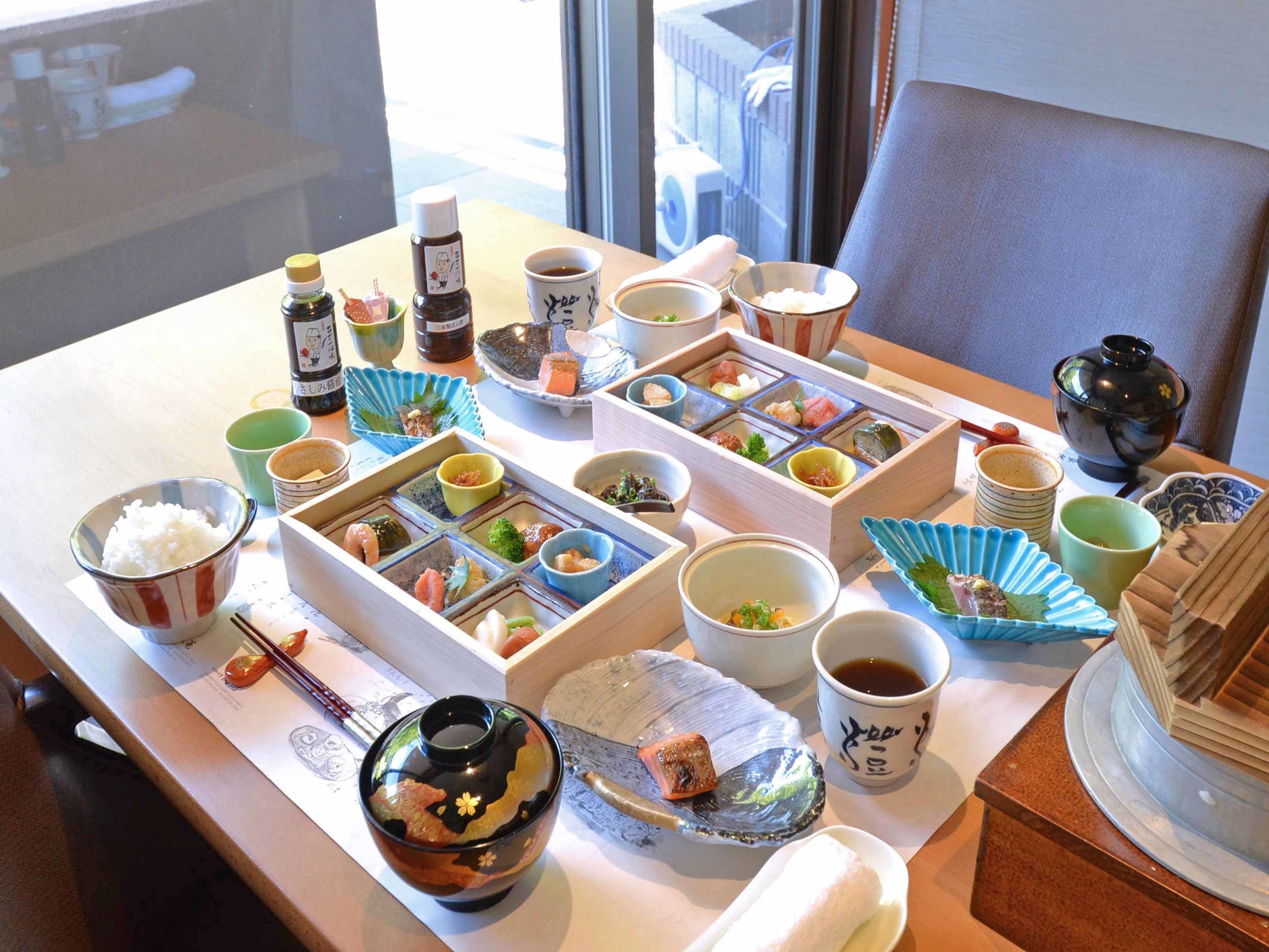 A table set with various Japanese dishes, including sushi, rice, and tea.