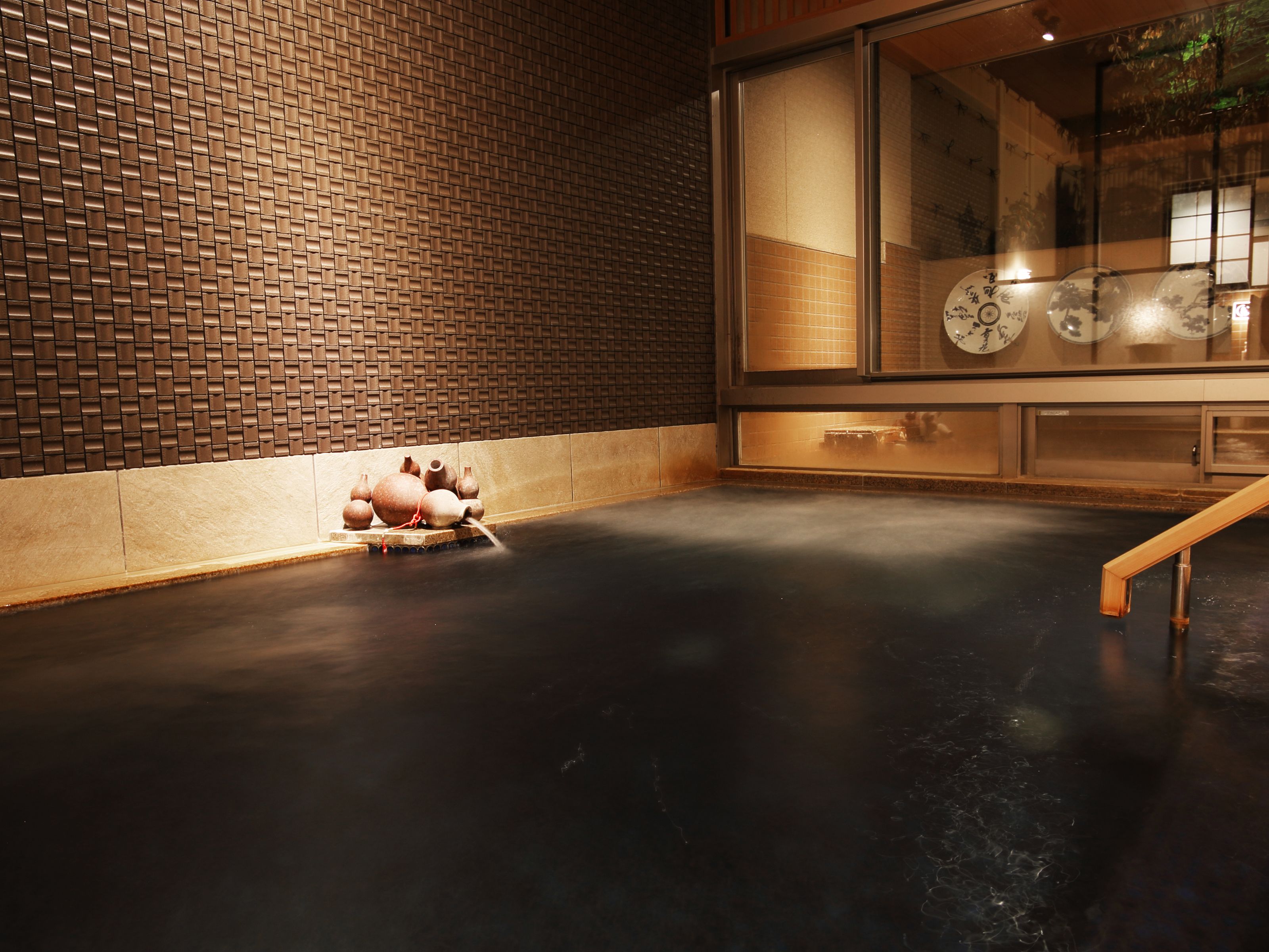A room with a brick-patterned wall, a large window with decorative elements, and a flat floor.