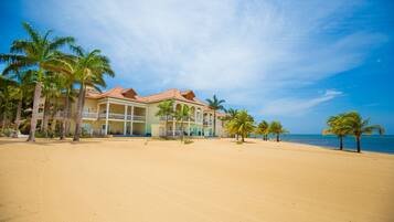 A beachfront hotel with multiple balconies and palm trees.