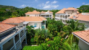 A resort with multiple buildings featuring red-tiled roofs, balconies, and lush tropical gardens. - Lawson Rock - Angelfish 202 (Roatan)