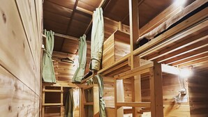 A wooden interior with bunk beds, a bench, and a hanging light fixture. - Hostel Otro Mundo (Kyoto)