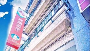 Un hotel de varios pisos con una entrada destacada, un área de recepción visible y balcones en los pisos superiores.