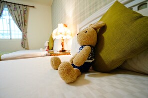 A bed with a teddy bear, a lamp, and a window with curtains. - Hualien Yashe House (Hualien City)