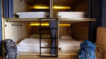 A bunk bed room with a ladder, a suitcase, and a guitar case.