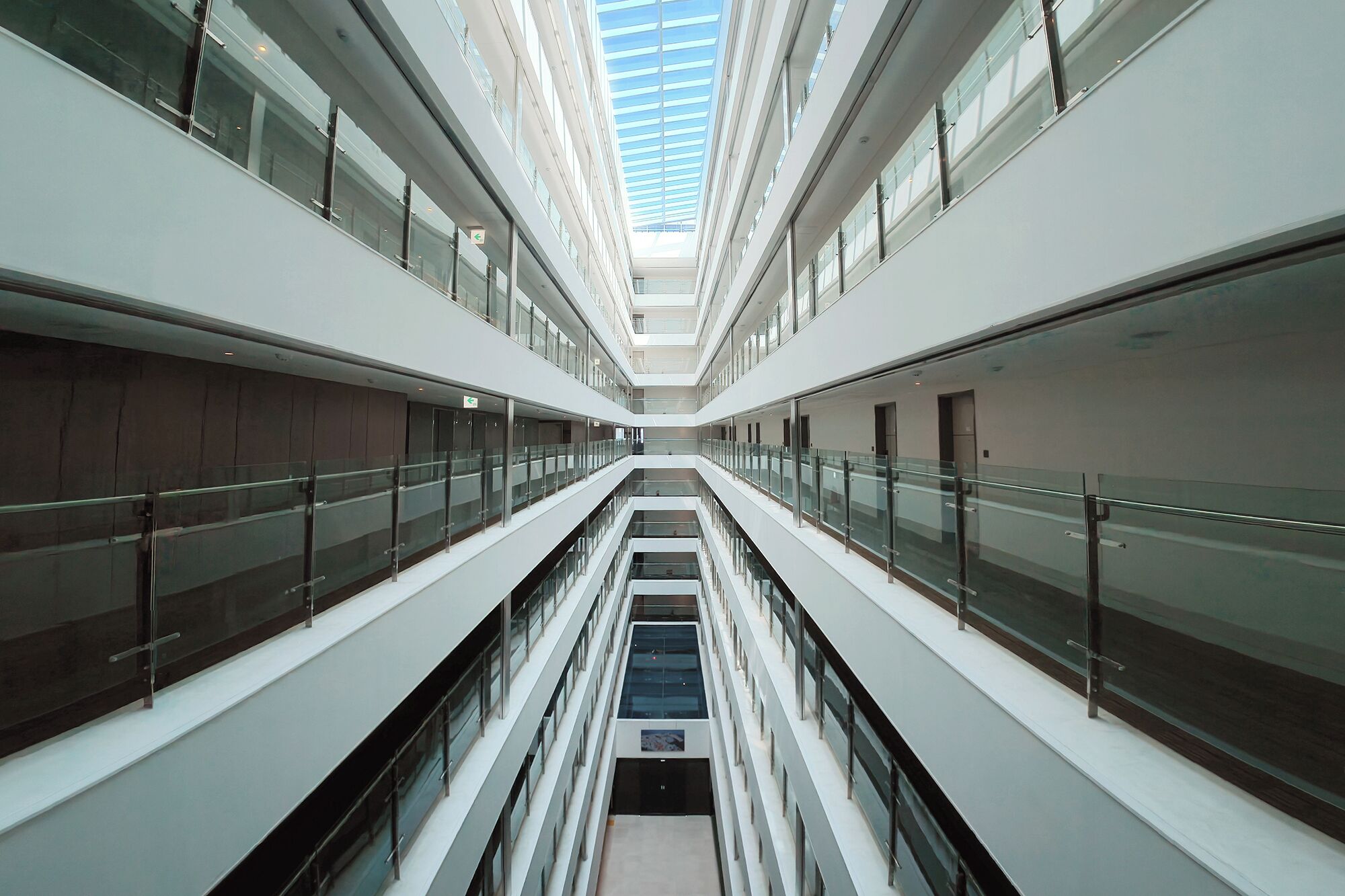 A multi-level atrium with glass railings and a central staircase.