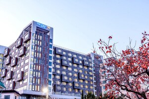Un edificio de hotel moderno con un letrero llamativo que dice 'THE FIRST HOTEL 70'.