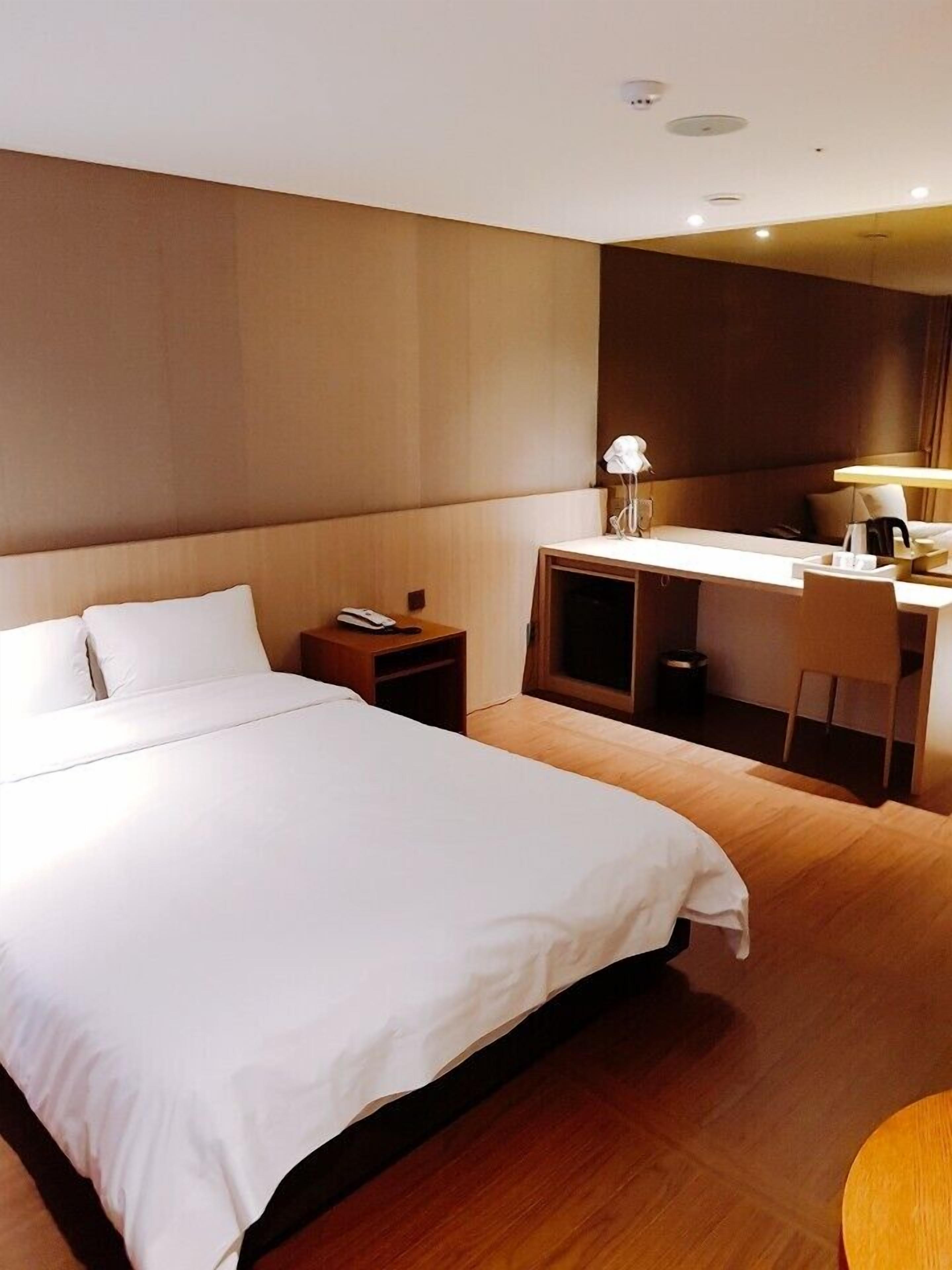 Een hotelkamer met een groot bed, een bureau en een stoel.