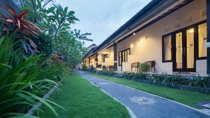 A pathway leading to a row of traditional-style buildings with large windows and a well-maintained garden.