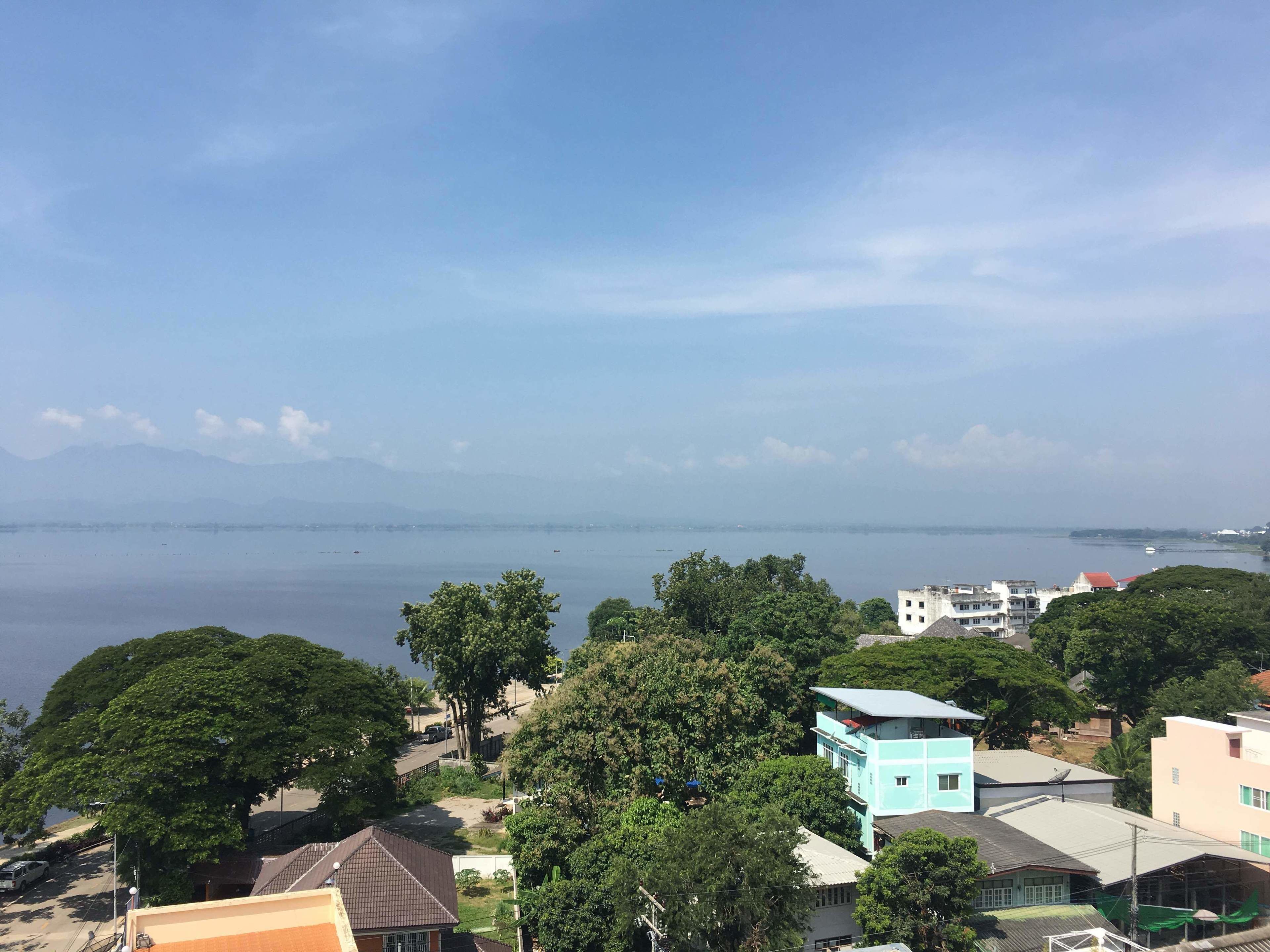 A coastal town with buildings, trees, and a view of the sea.