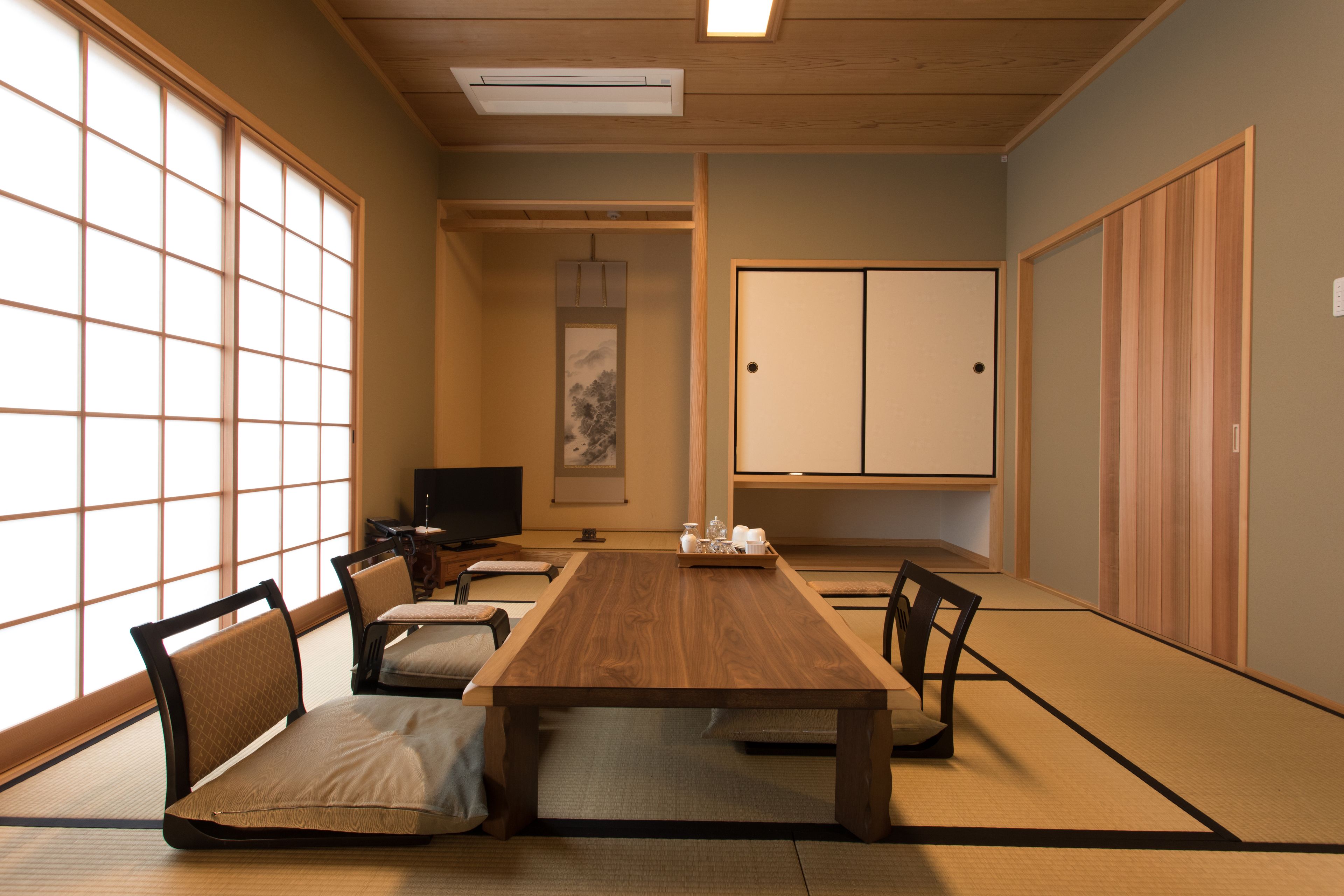 A traditional Japanese-style room with tatami flooring, a low wooden table, and shoji screens.