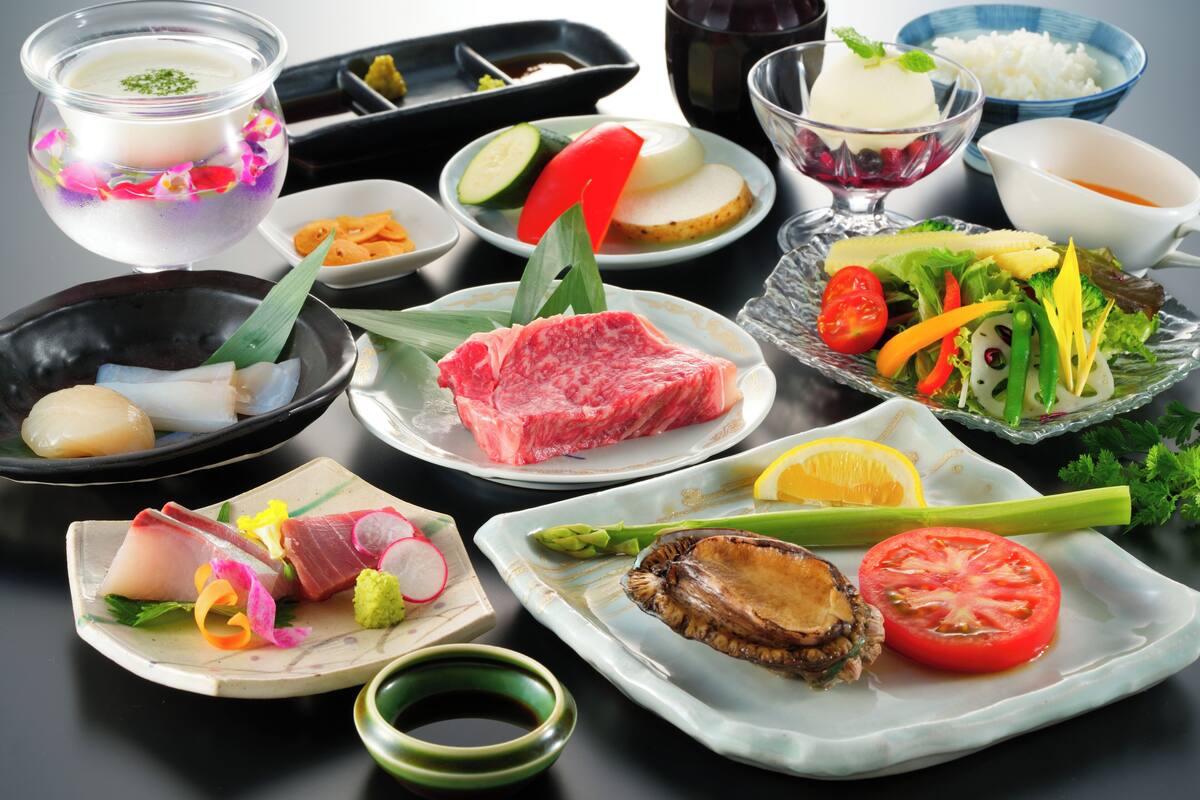 A variety of dishes including raw meat, vegetables, and rice, suggesting a meal setting.