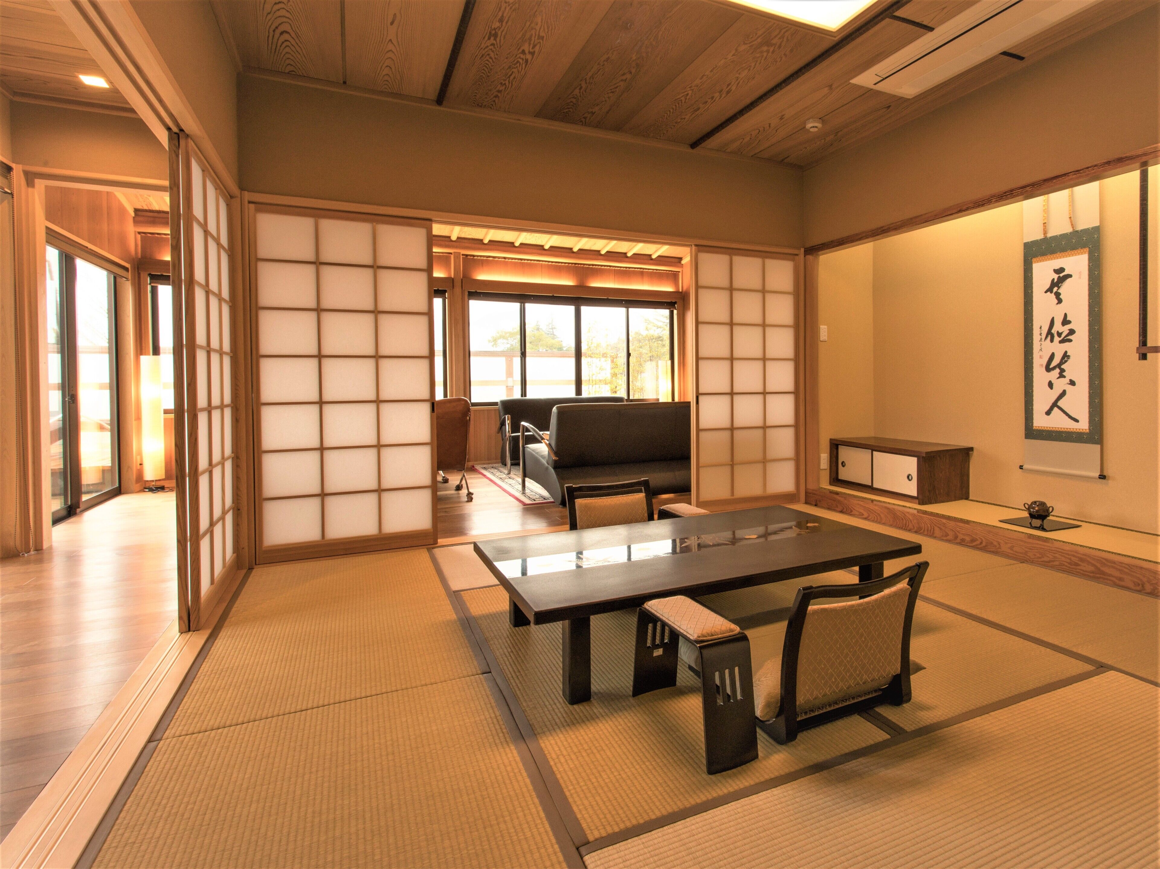 A traditional Japanese room with tatami flooring, a low table, and a sofa.