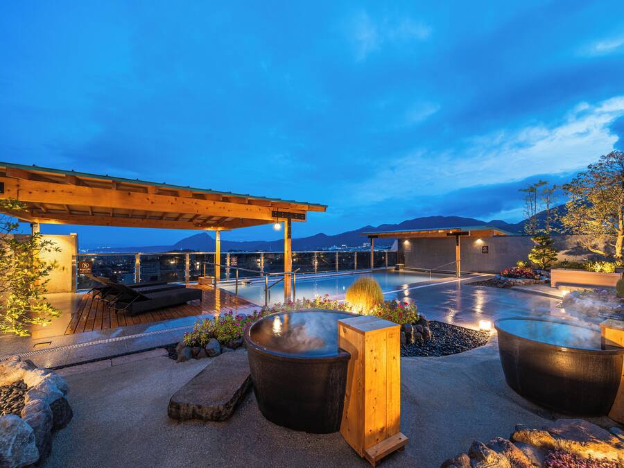 Terraza en la azotea con jacuzzi, zona de estar y pérgola.