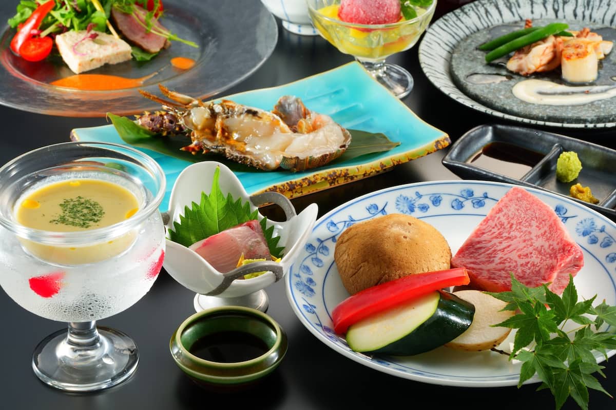 A variety of dishes including seafood, vegetables, and a dessert, served on different plates and bowls.