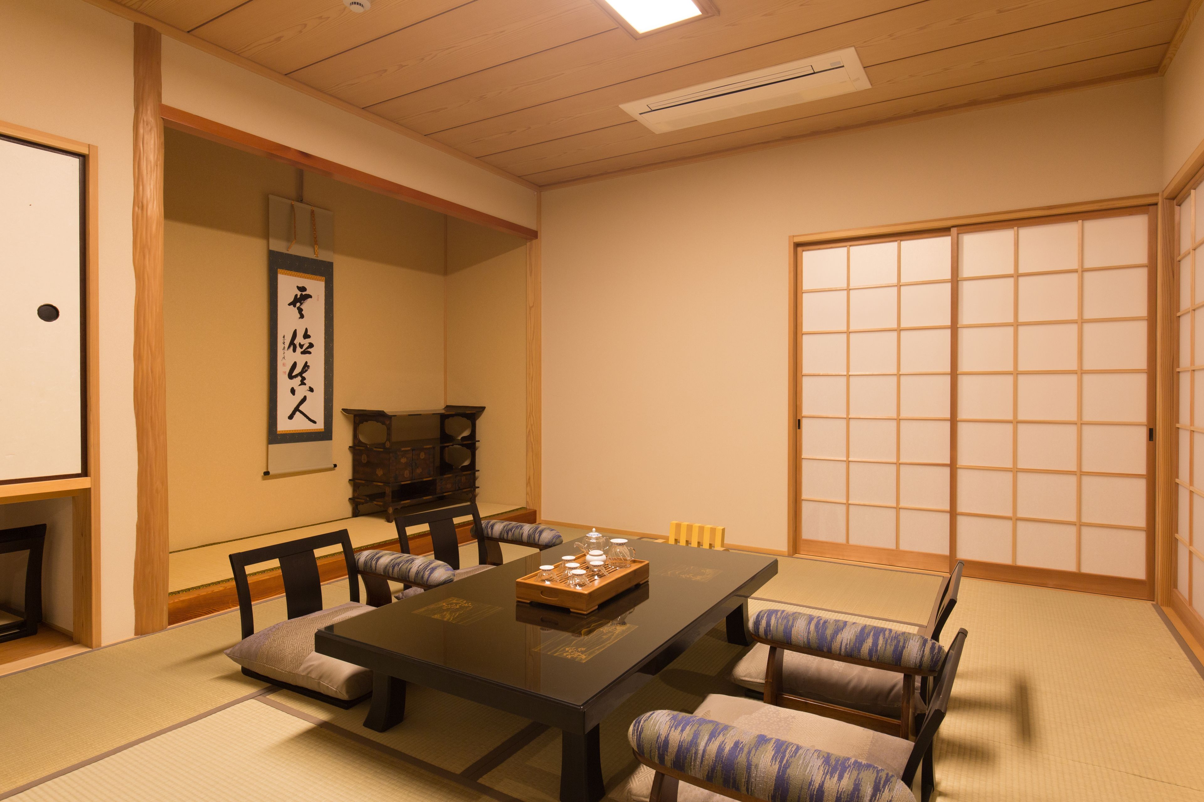 Ein traditioneller japanischer Raum mit Tatami-Boden, einem niedrigen Tisch und Shoji-Schirmwänden.