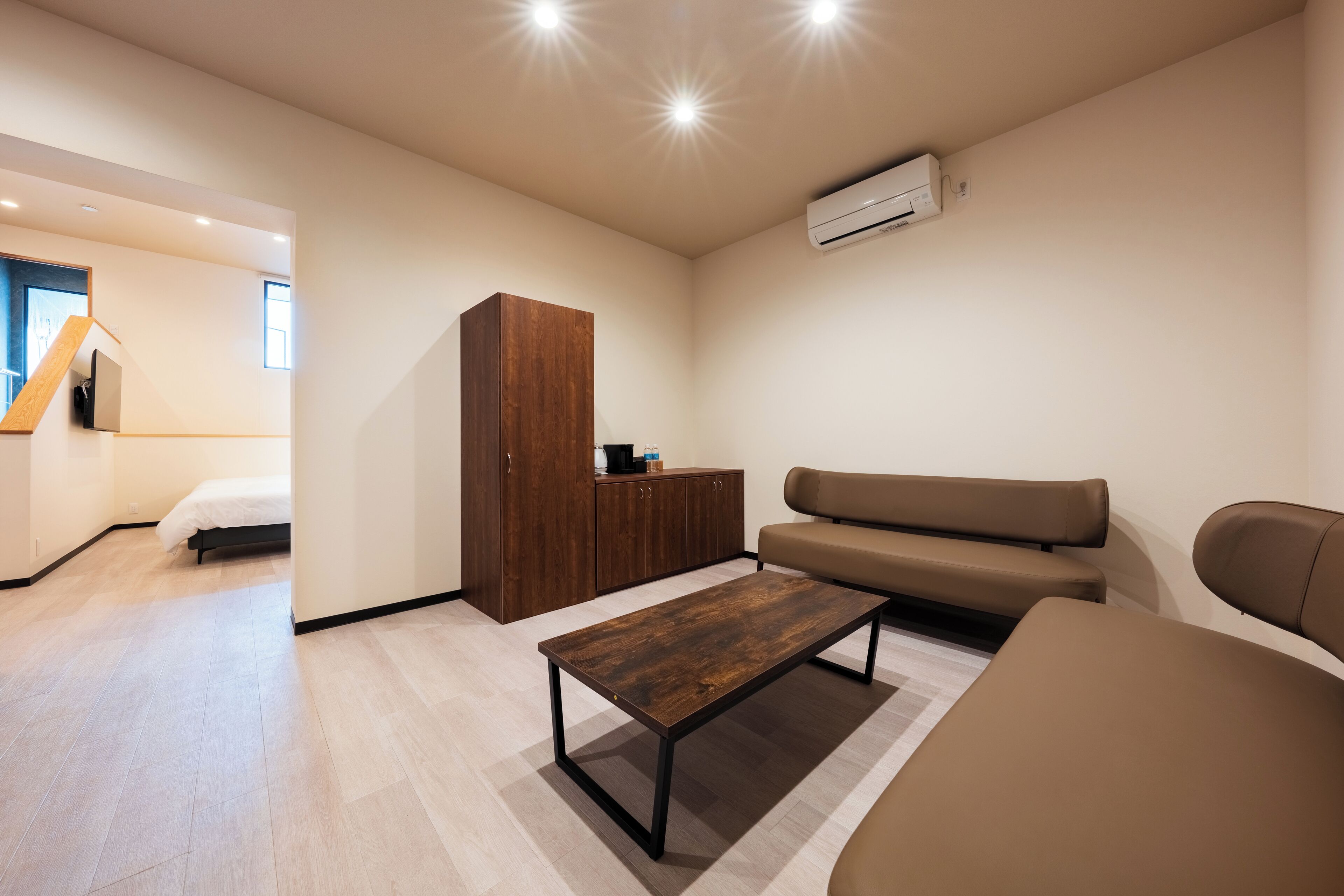 A modern living room with a sofa, a coffee table, and a wooden cabinet.