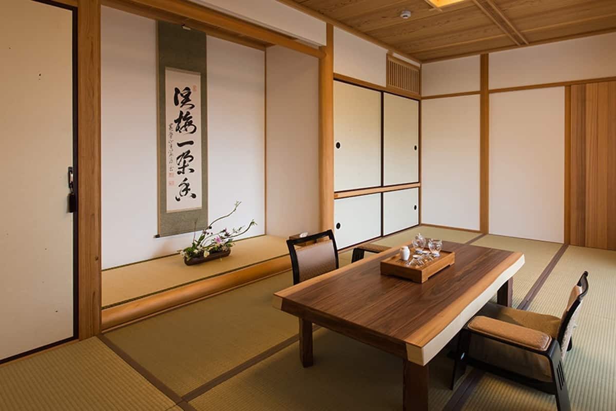 A traditional Japanese room with tatami flooring, a low wooden table, and sliding doors.