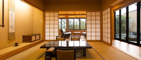 A traditional Japanese-style room with tatami flooring, a low table, and shoji screens.
