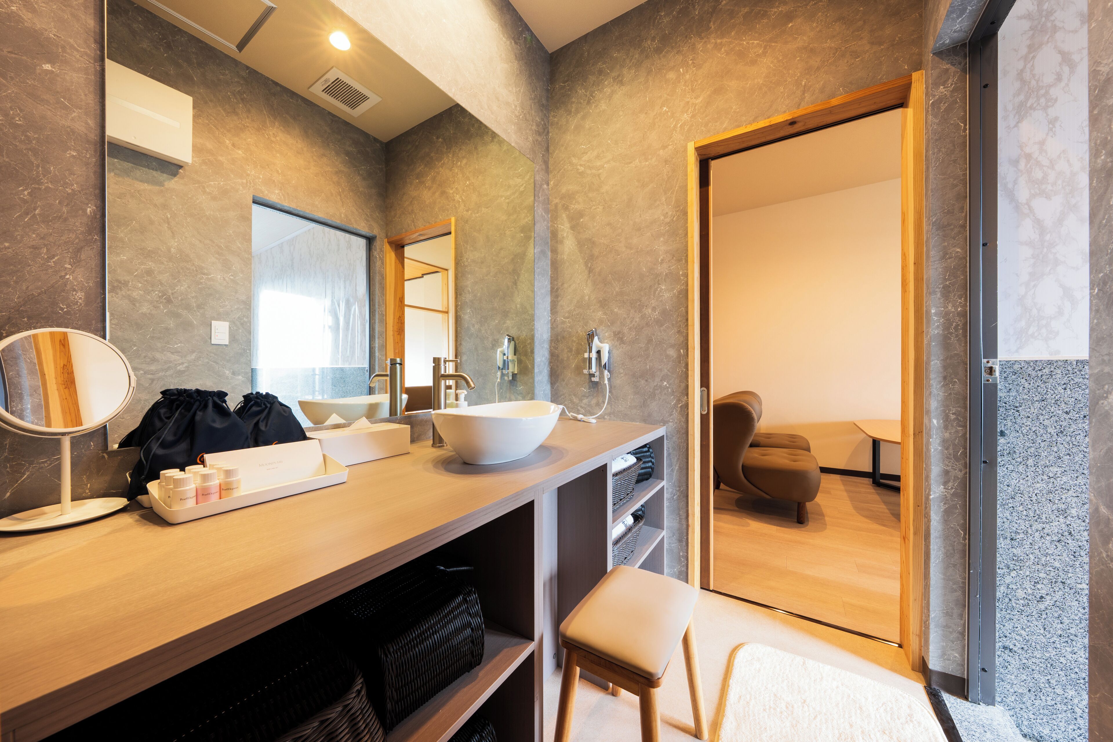 A modern bathroom with a large mirror, a sink with a vessel basin, and a wooden vanity.
