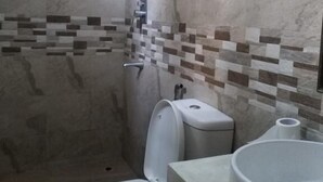 A bathroom with a shower, toilet, and sink. - Nishan Surf Inn (Matara)