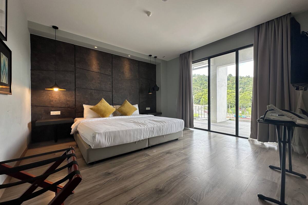 Una camera da letto moderna con un letto grande, una scrivania e vista sul verde dalla finestra.