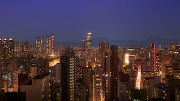 A nighttime cityscape with high-rise buildings and illuminated streets.