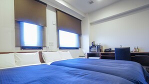Une chambre d’hôtel avec deux lits, un bureau, une chaise, un four à micro-ondes et un mini-bar.