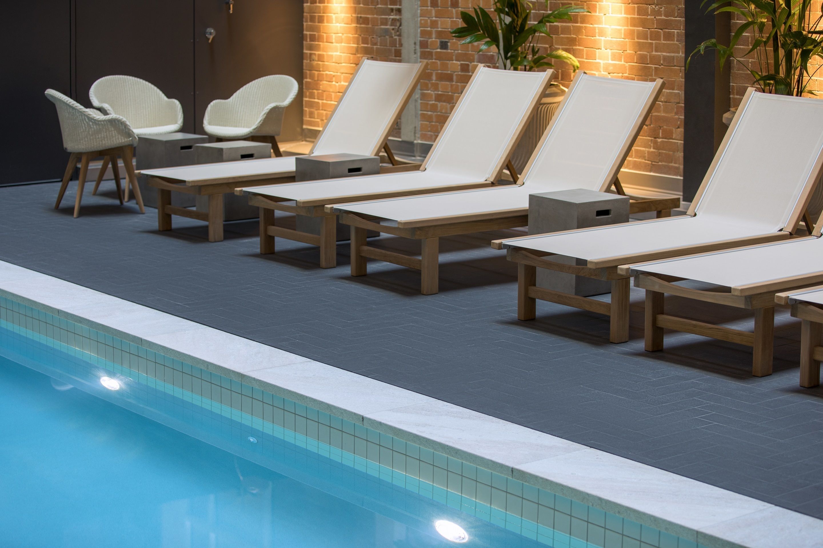 A poolside area with lounge chairs and a small seating area.