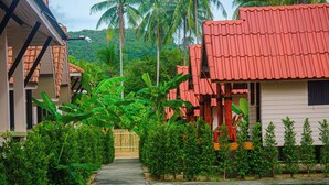 A pathway leading to a building with a red roof and a white exterior.