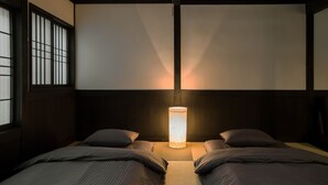 Une pièce de style japonais traditionnel, avec un sol recouvert de tatamis, un plafond bas en bois et une porte coulissante de type shoji.