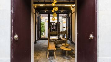 A wooden bench and tables in a doorway, with hanging lights above.