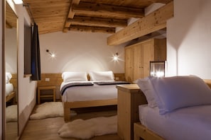 A cozy bedroom with a wooden ceiling, a bed with white bedding, a small bedside table, and a mirror. - Chalet-Hôtel Borgo Eibn Mountain Lodge (Relais du Silence) (Sauris)