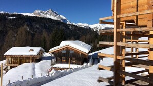 A wooden cabin with a snow-covered roof, surrounded by snow and mountains in the background. - Chalet-Hôtel Borgo Eibn Mountain Lodge (Relais du Silence) (Sauris)