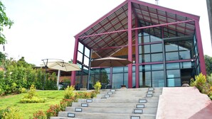 A modern building with a glass facade and a red metal structure. - Lanta Hostel - Adults Only (Ko Lanta)