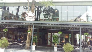 A cafe and bakery with outdoor seating, a large glass window, and a sign above the entrance. - Trang An Hotel (Hoa Lu)