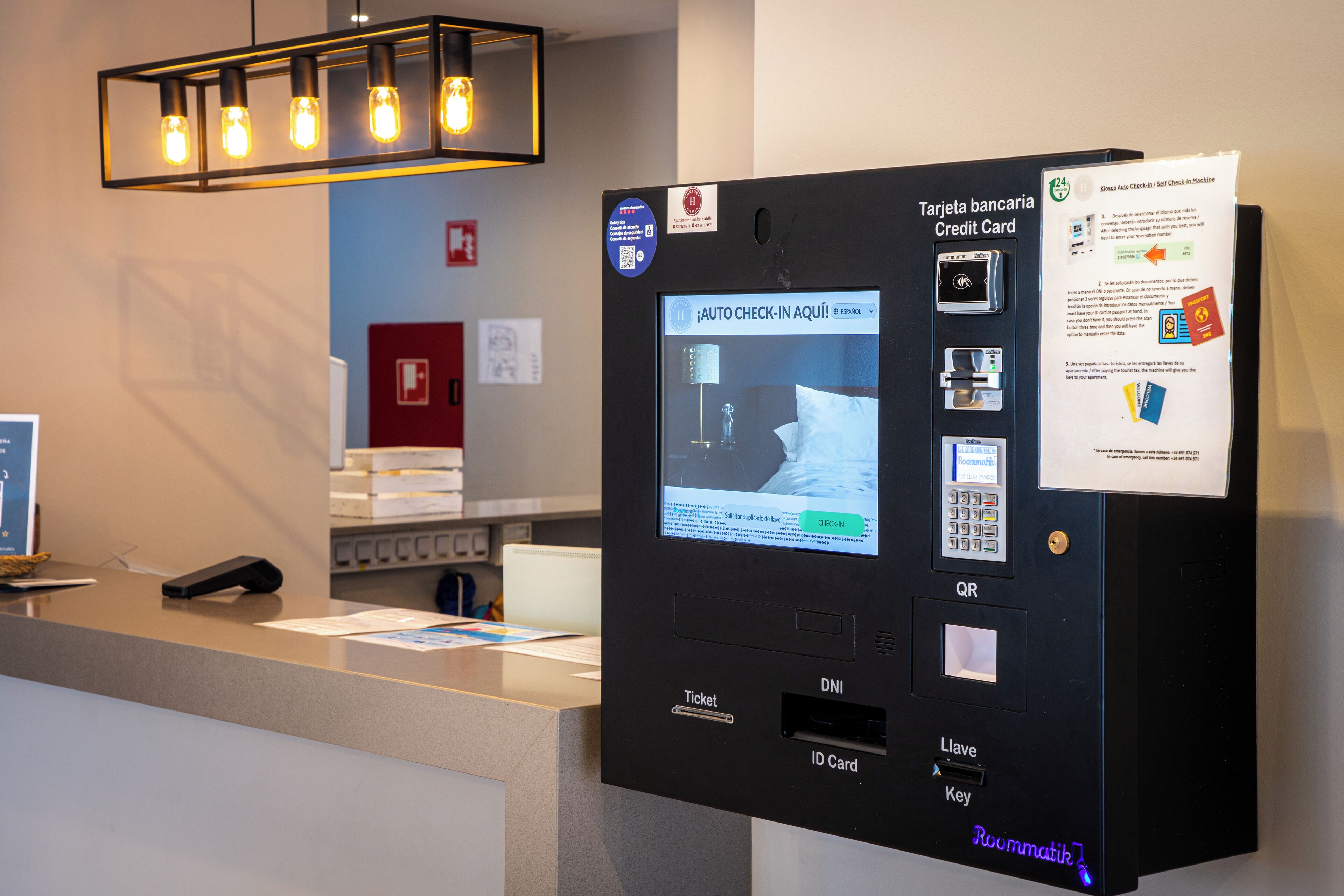 Een zelfbedieningskiosk voor inchecken, met een digitaal scherm, een QR-code en een gleuf voor een creditcard.