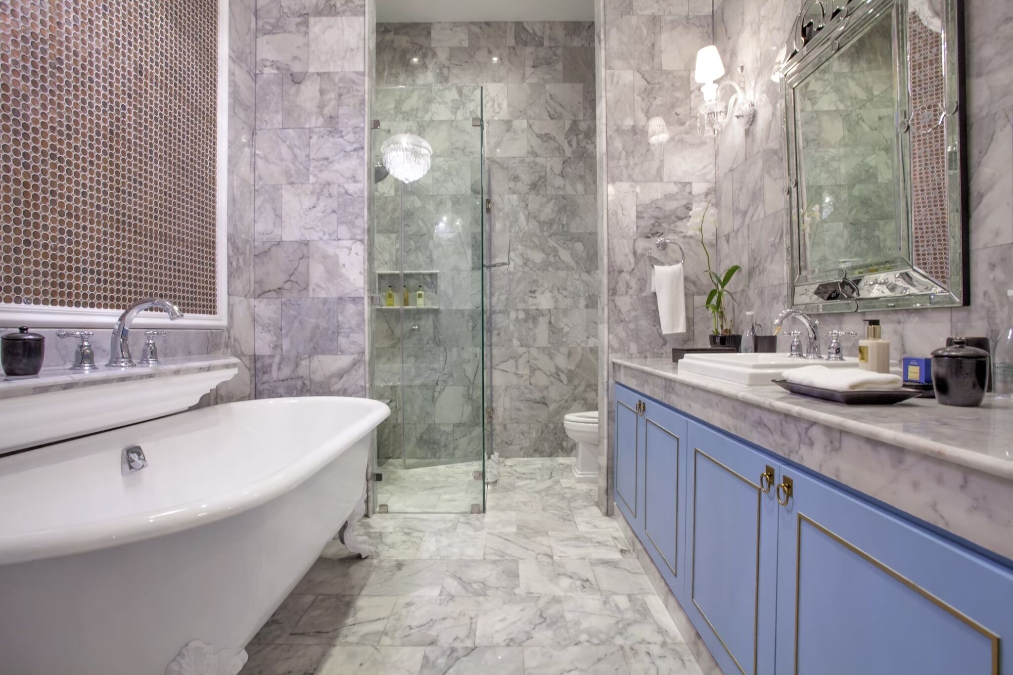 Un baño con bañera independiente, ducha con mampara de vidrio y tocador con espejo.